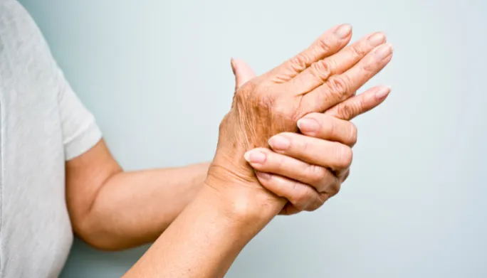 Older adult exercising a joint affected by arthritis with a therapist