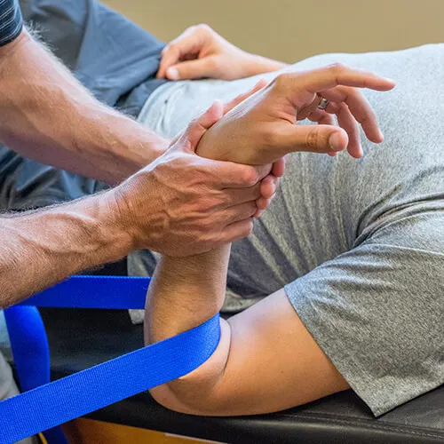 Physical therapist examining a patient's wrist and arm