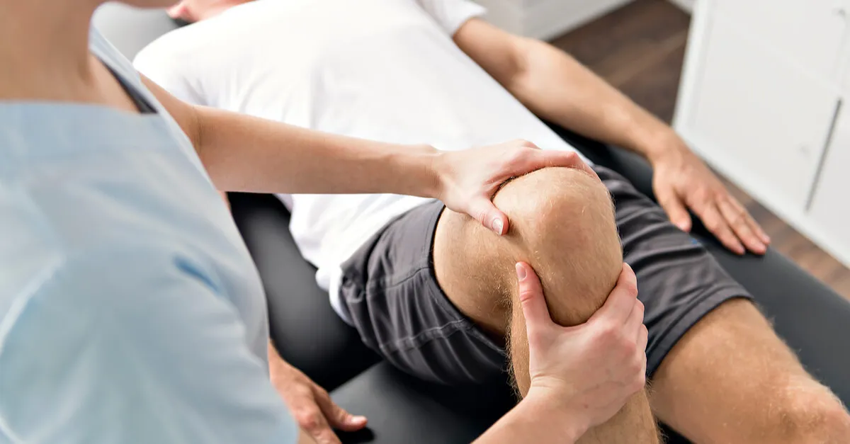 Therapist rehabilitating a patient's hip and knee
