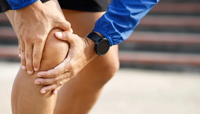 Therapist assessing a patient's stiff, aching joint