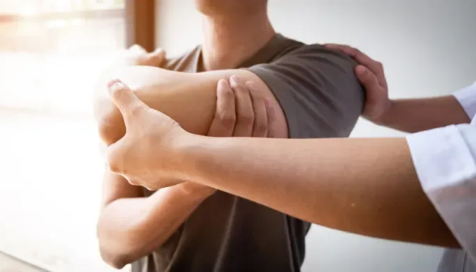 Therapist assessing a patient's shoulder and rotator cuff