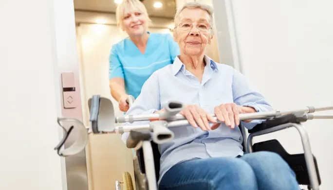 Therapist helping a patient in a wheelchair during stroke recovery