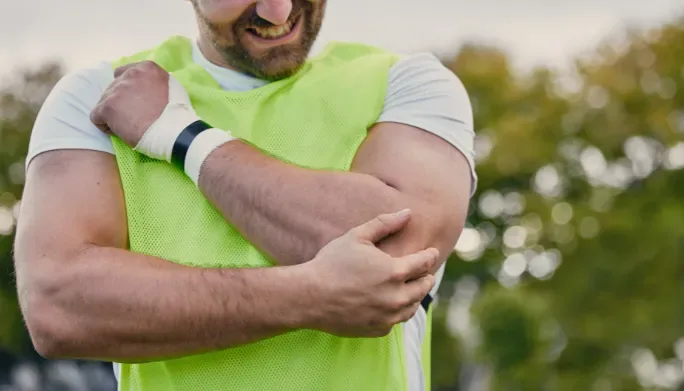 Athlete holding his elbow in pain from tendinitis